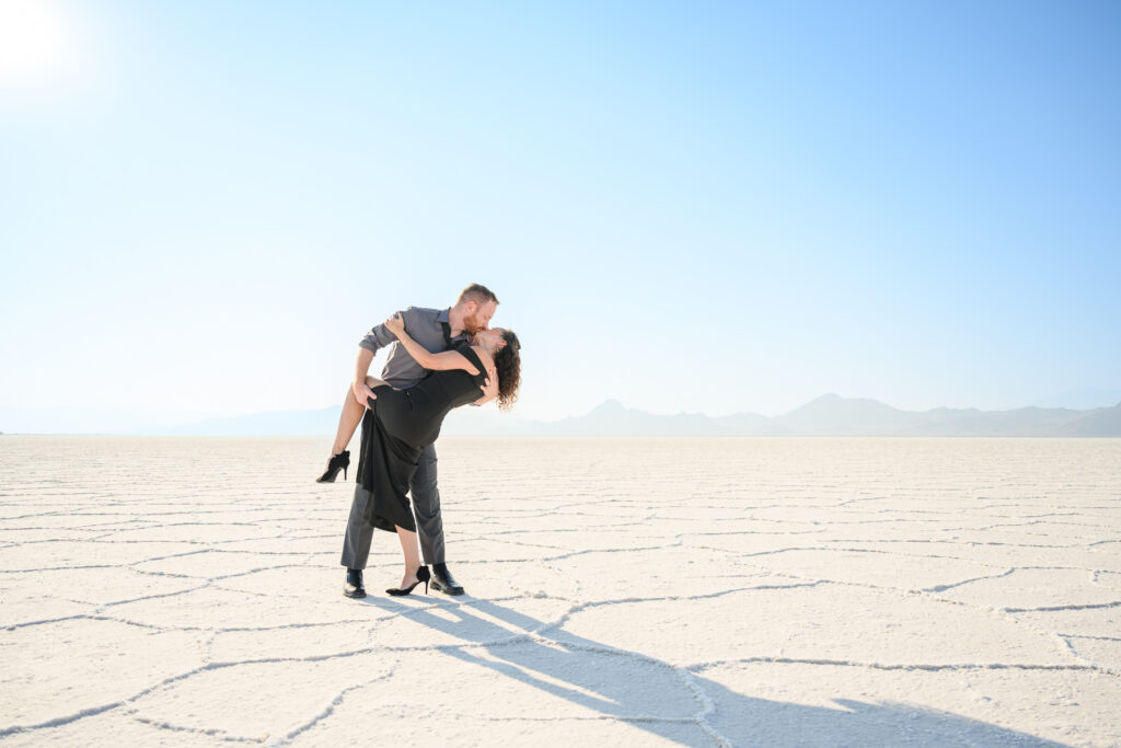 Couple standing on Bonneville Salt Flats reflective surface
