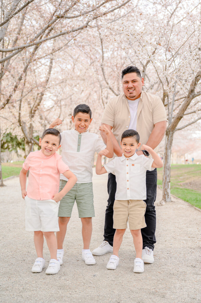 dad and sons posing at Utah state capitol blossoms spring family photos by a utah family photographer