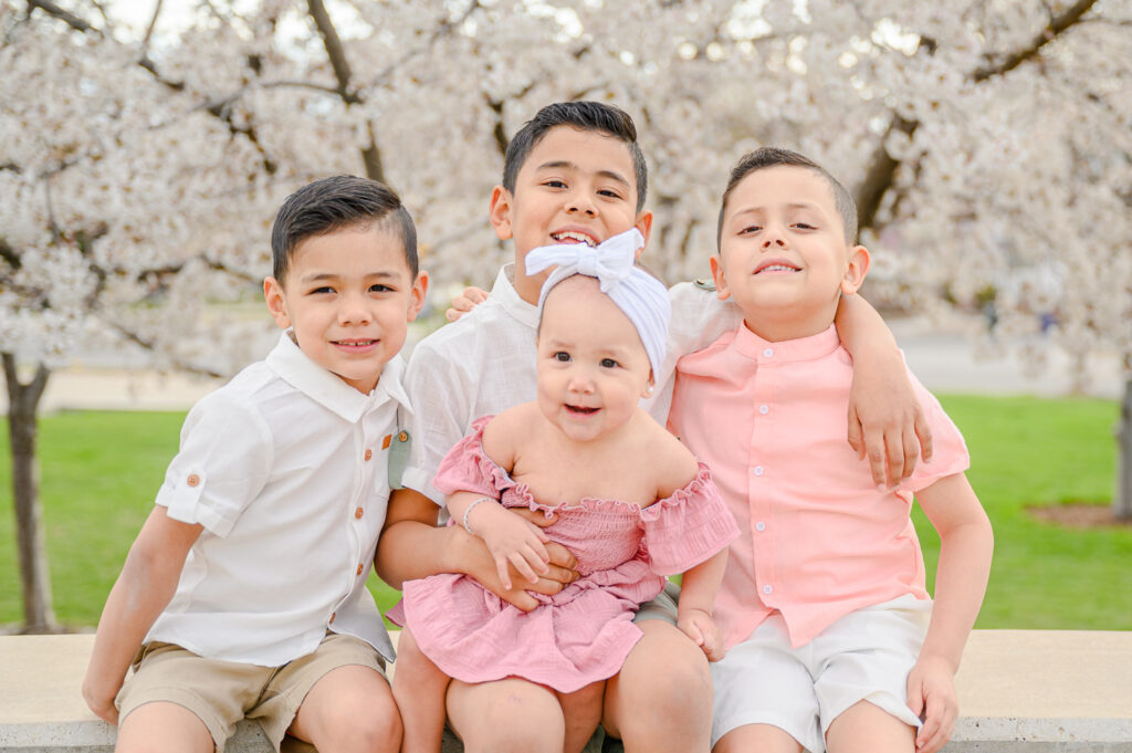 kids sitting Utah state capitol blossoms spring family photos by a utah family photographer