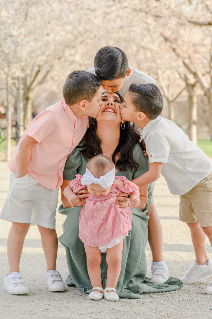 all the kids kissing mom at Utah state capitol blossoms spring family photos by a utah family photographer