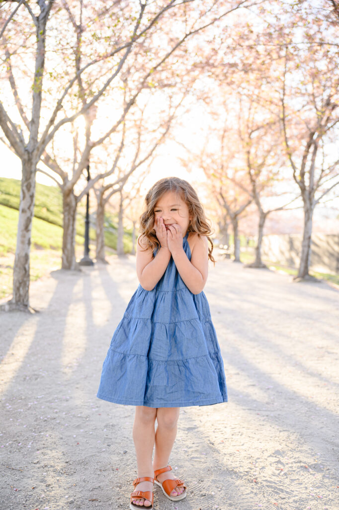 • Young siblings playing near blossom trees during Utah spring photo session
