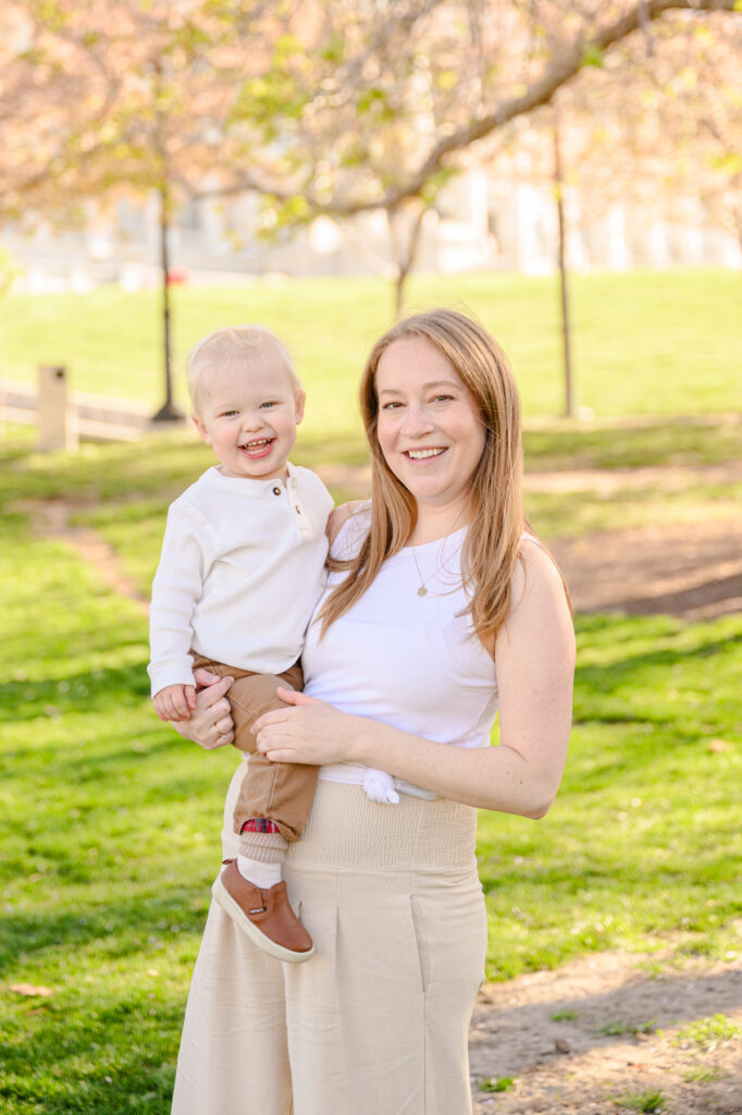 • Laughing family standing along blossom-lined pathway at Utah State Capitol