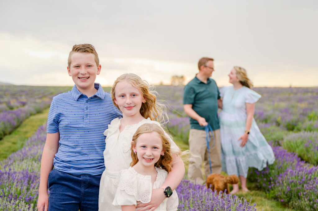 Family posing in the lavender field for family pictures taken by the best family photographer in utah
