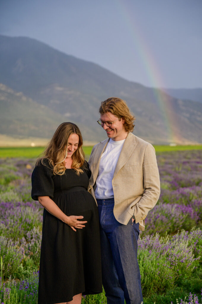 maternity posing in the lavender field for family pictures taken by the best family photographer in utah
