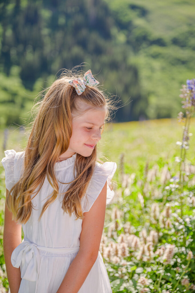 photo of a girl in the wildflowers up little cottonwood canyon for family pictures taken by luxury utah family photographer