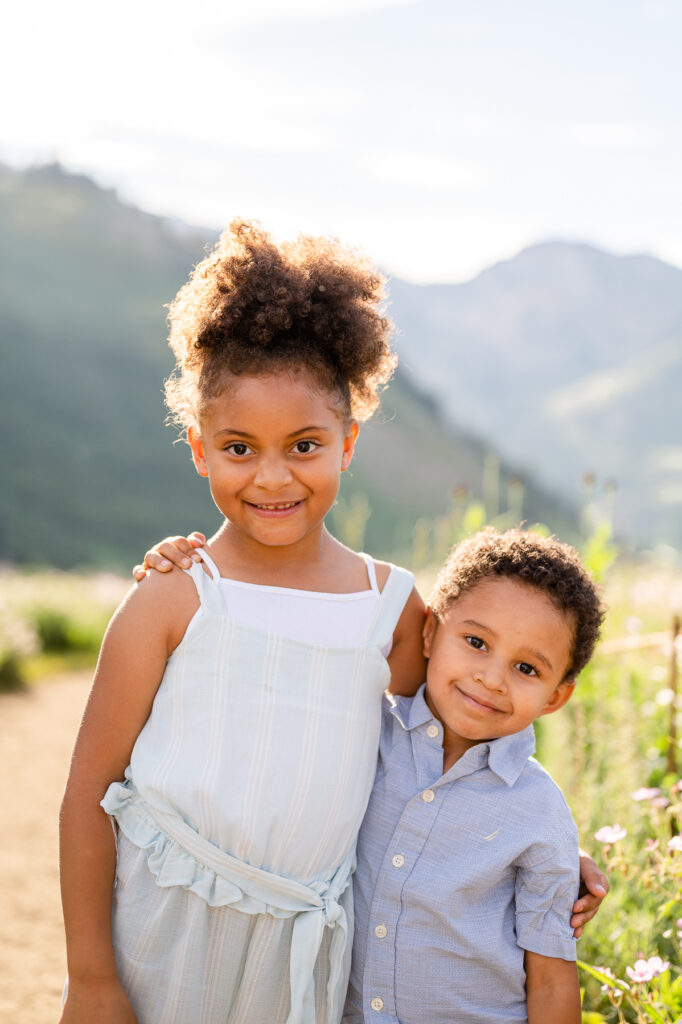 photo of two kids in the wildflowers up little cottonwood canyon for family pictures taken by luxury utah family photographer